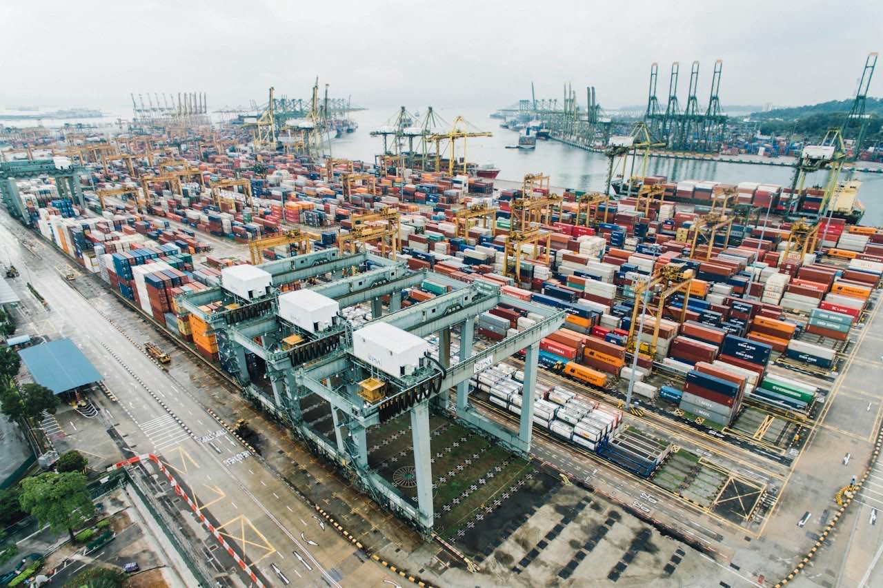 Aerial view of a container terminal with stacked shipping containers and gantry cranes